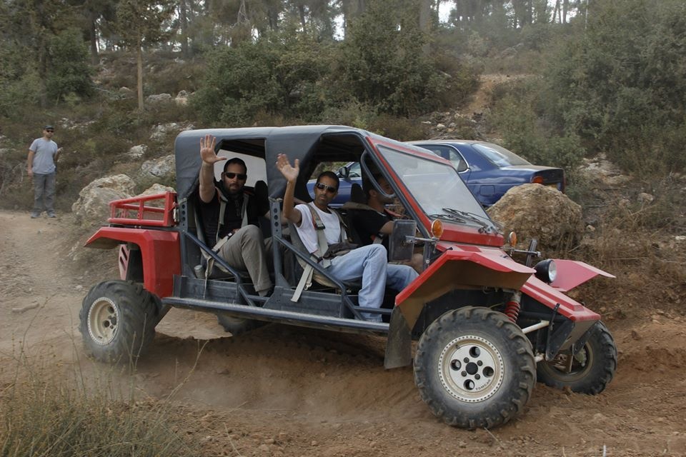 Matzok friends waving from red buggy on forest dirt trail