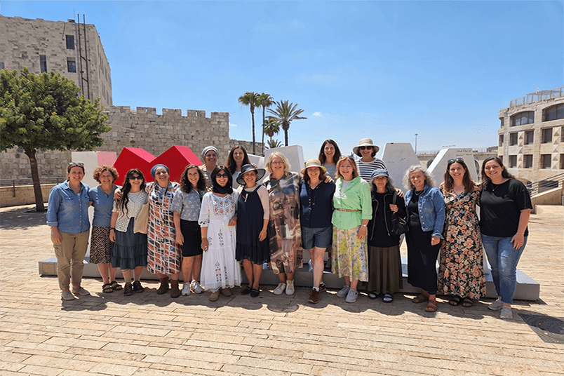 קבוצת משתתפים במסע המרכבה עומדת יחד ליד חומות העיר העתיקה בירושלים