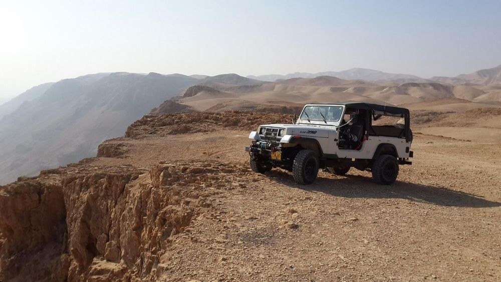 Matzok jeep parked at desert cliff edge overlooking Judean Desert