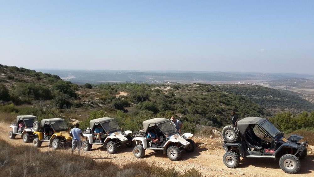 Matzok off road buggies lined up at hilltop viewpoint with green valley